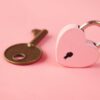 a heart shaped lock and a key on a pink background