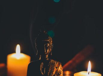 sitting buddha beside pillar candles